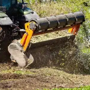Picture of a tractor specialized in forest clearing that is in the process of destroying all the trees and bushes.