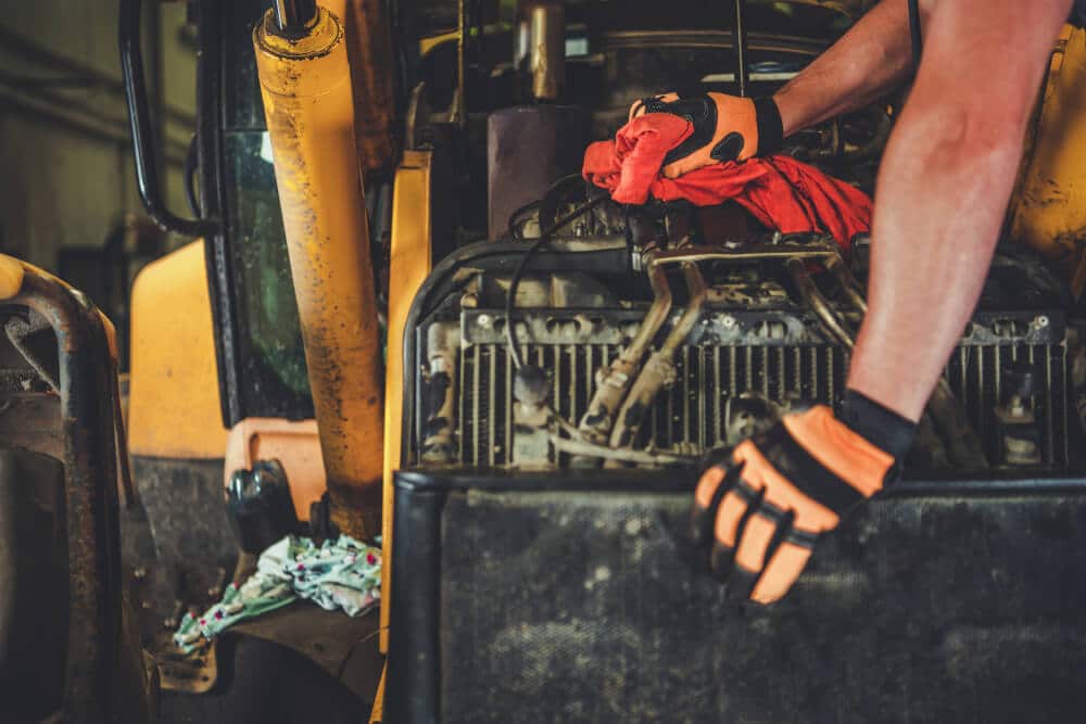 Réparation de bulldozer par Professionnel Caucasian Mechanic. Photo en gros plan. 